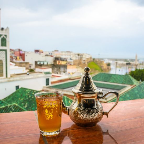 Traditional Moroccan mint tea and panorama of old medina in city Tangier, Morocco
