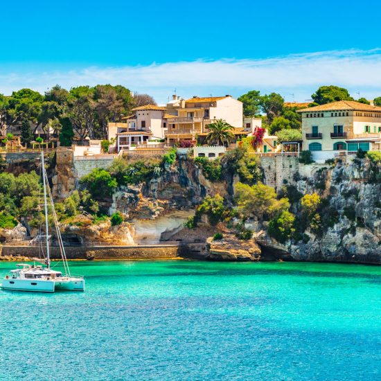 Beautiful view of bay with sailing boat at the seaside of Porto Cristo on Mallorca, Spain Mediterranean Sea