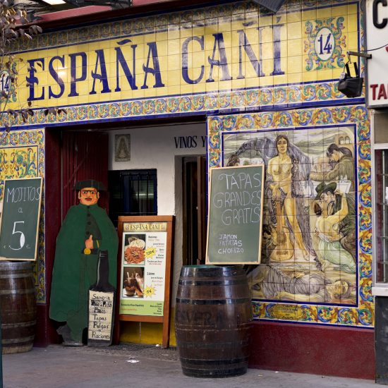 "Madrid, Spain - October 16, 2011:Entry of a typical Spanish bar for tapas and beer and wine. Facade decorated with tiles, and casks of wine."